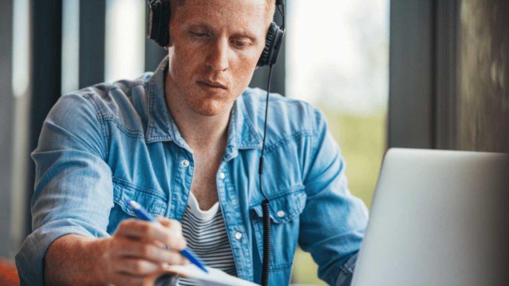 inlingua Andorra student on laptop with headphones