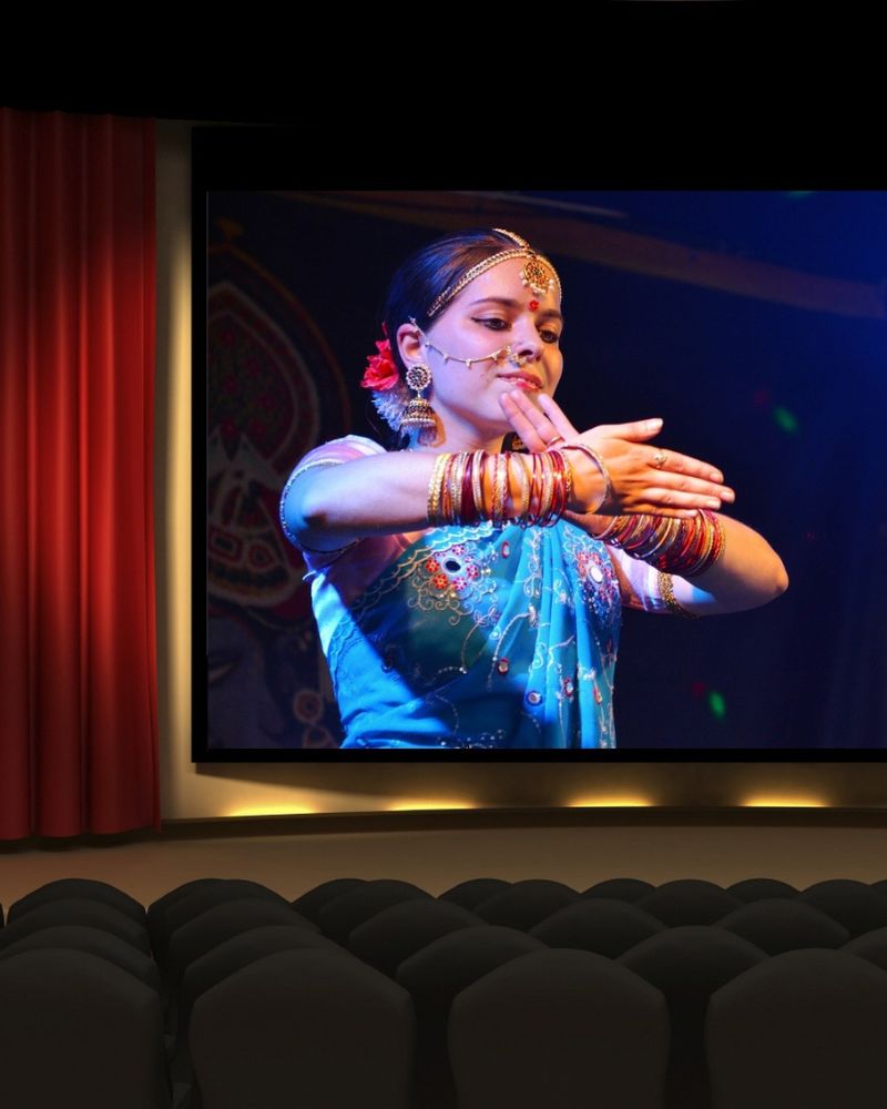 Bollywood actress on movie screen. Woman of Indian heritage dancing with traditional Indian attire
